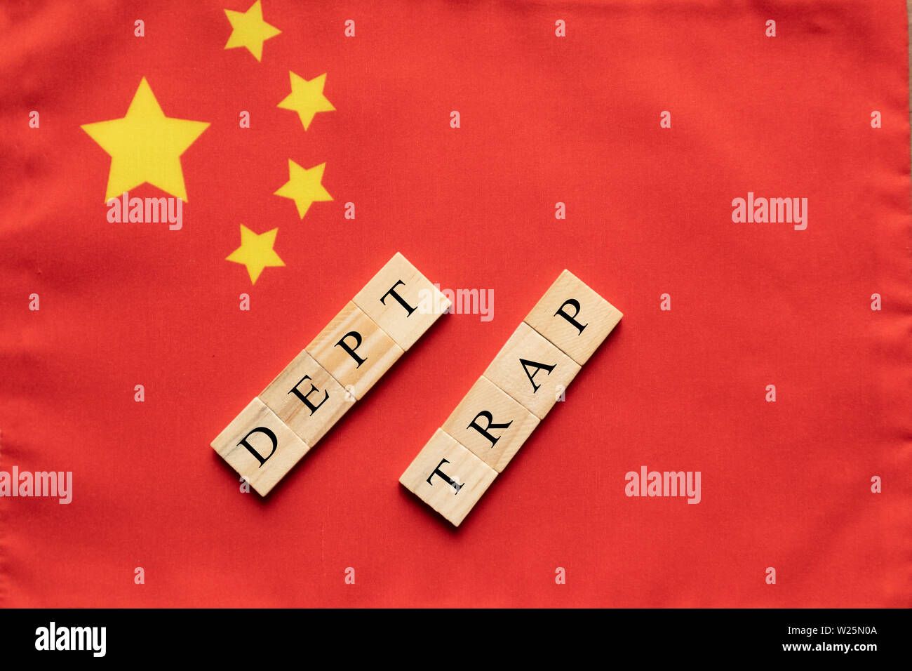 Concept of dept trap in wooden block letters on Chinese flag Stock Photo