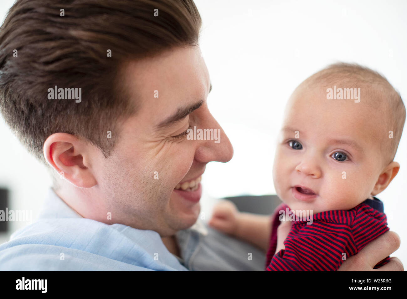 Loving Father Cuddling Cute Baby Son At Home Stock Photo