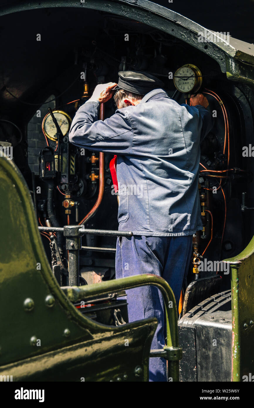 Driver on a heritage railway vintage steam train Stock Photo