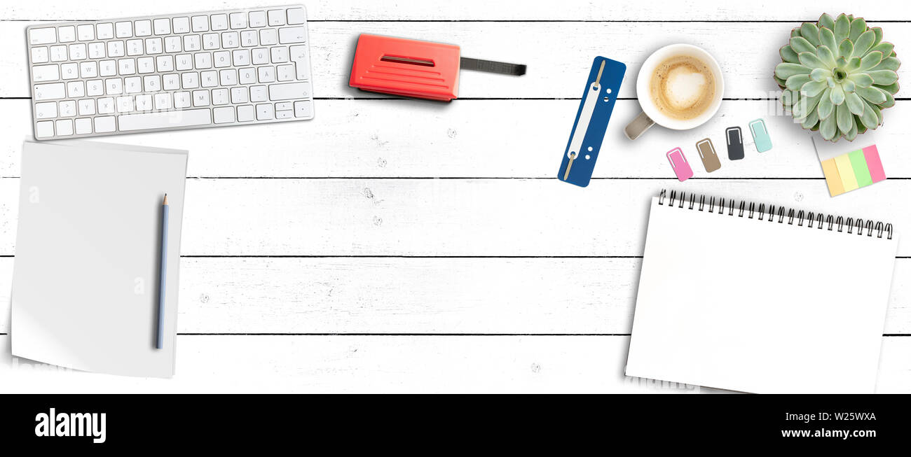 top view of clean modern office workspace, wooden desk with computer keyboard, notepad, coffee mug and office supplies Stock Photo