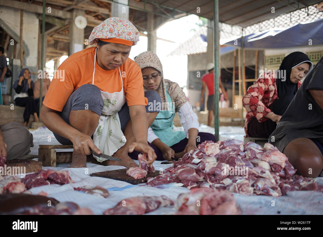 Moslem slicing goat meat when Eid Al Adha in Semarang, Indonesia Stock Photo