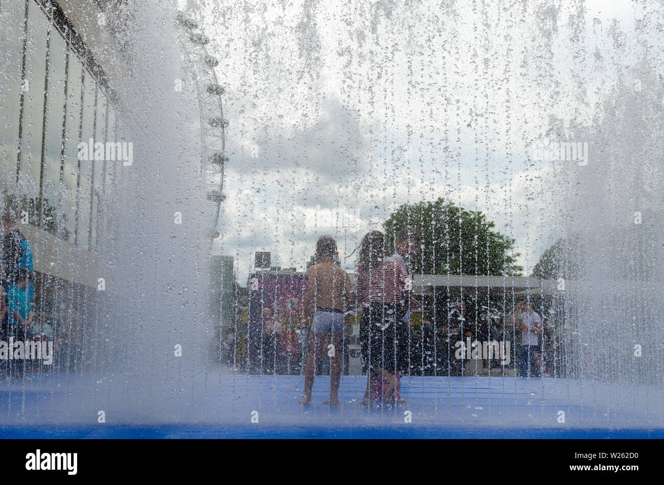 Children cooling down in the summer heat wave inside a fountain in London, England Stock Photo