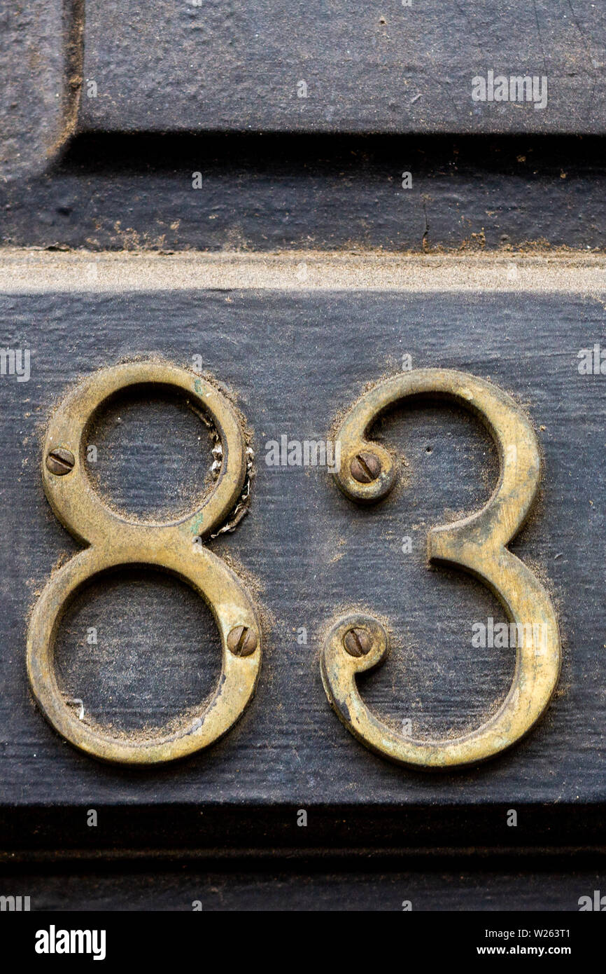 House number 83 with the eighty-three in metal digits on a wooden front door Stock Photo