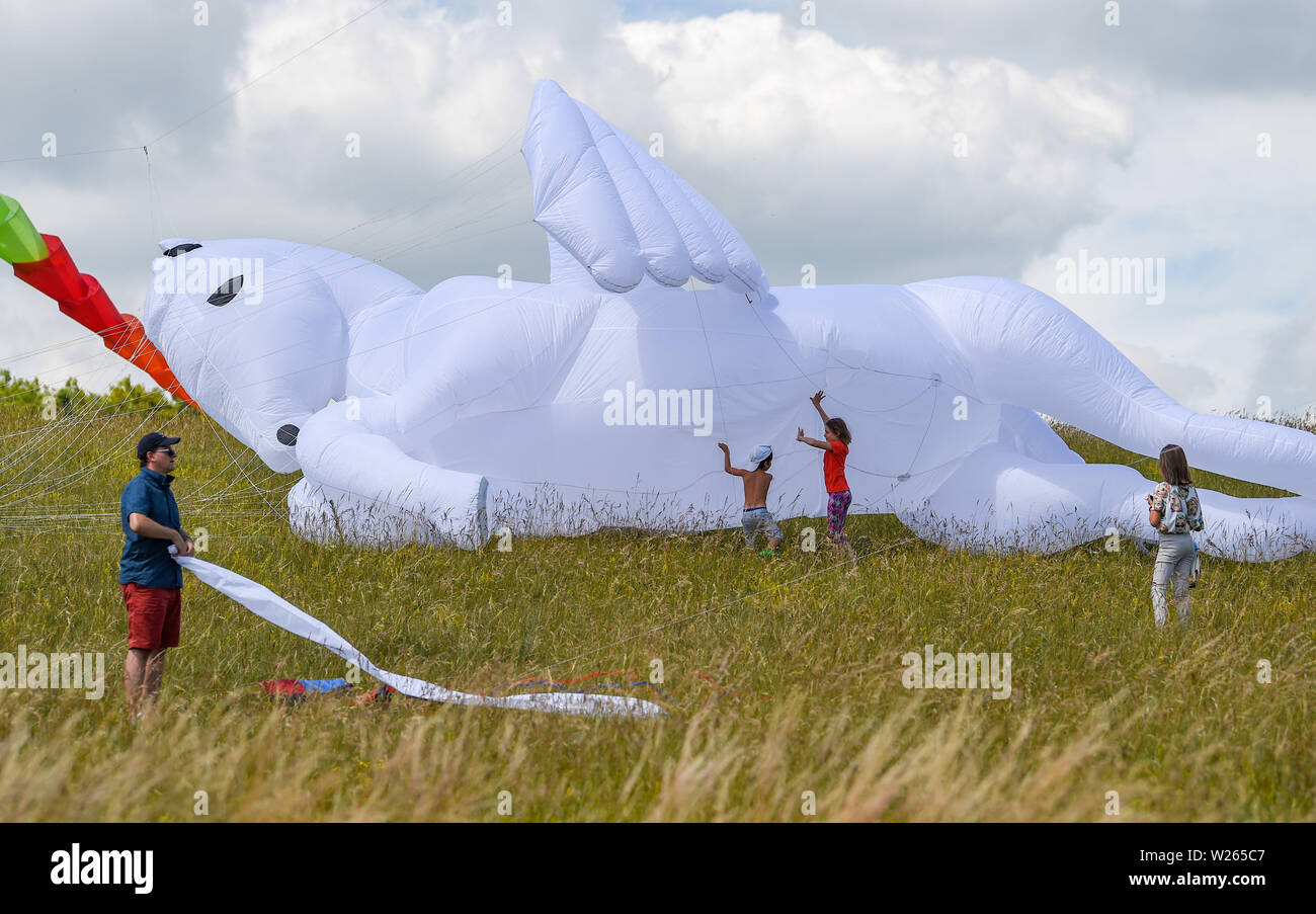 Brighton UK 6th July 2019 - A giant white pegasus kite is launched on a beautiful sunny day at the start of the annual Brighton Kite Festival held in Stanmer Park and continues over the weekend . The wind conditions were poor at the start of the day but picked up in the afternoon as kite flying enthusiasts from around the world took part along with members of the public . Credit: Simon Dack / Alamy Live News Stock Photo