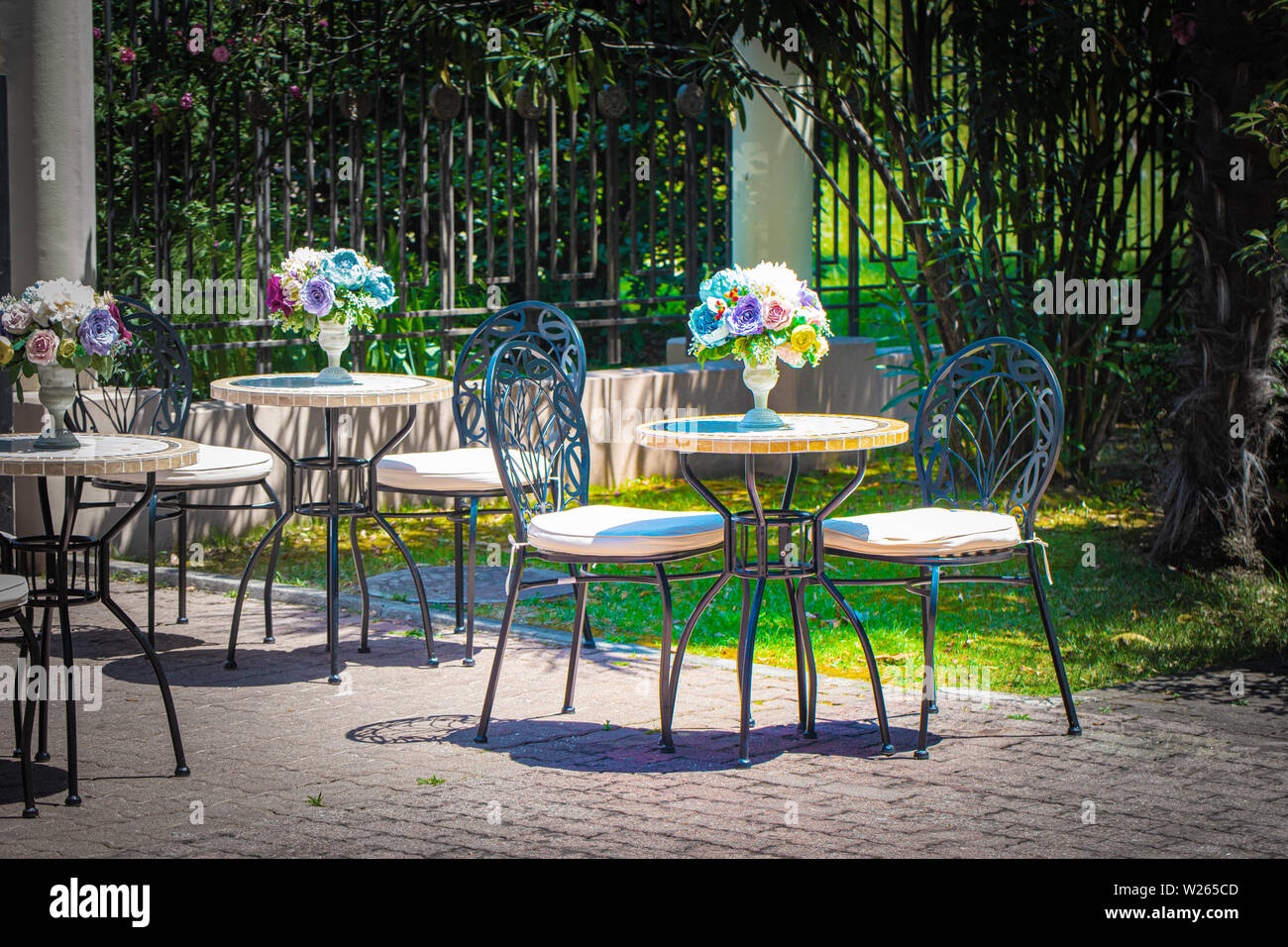 Outdoor cafe tables with flowers. Romance of the city. Stock Photo