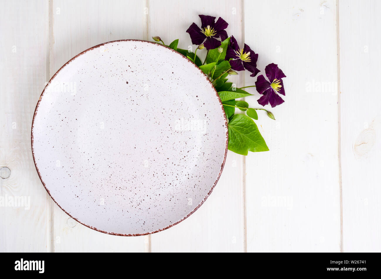 Plate with violet flowers, mock up for menu. Stock Photo