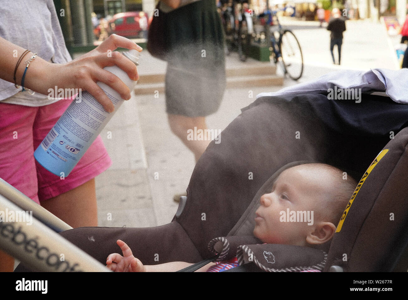 Avignon, France. Saturday, 6 July, 2019. A local, Jacqueline Escolivet, sprays water on her 3-month old baby to keep cool during hot weather during the Avignon theatre festival. Photo: Roger Garfield/Alamy Live News Stock Photo