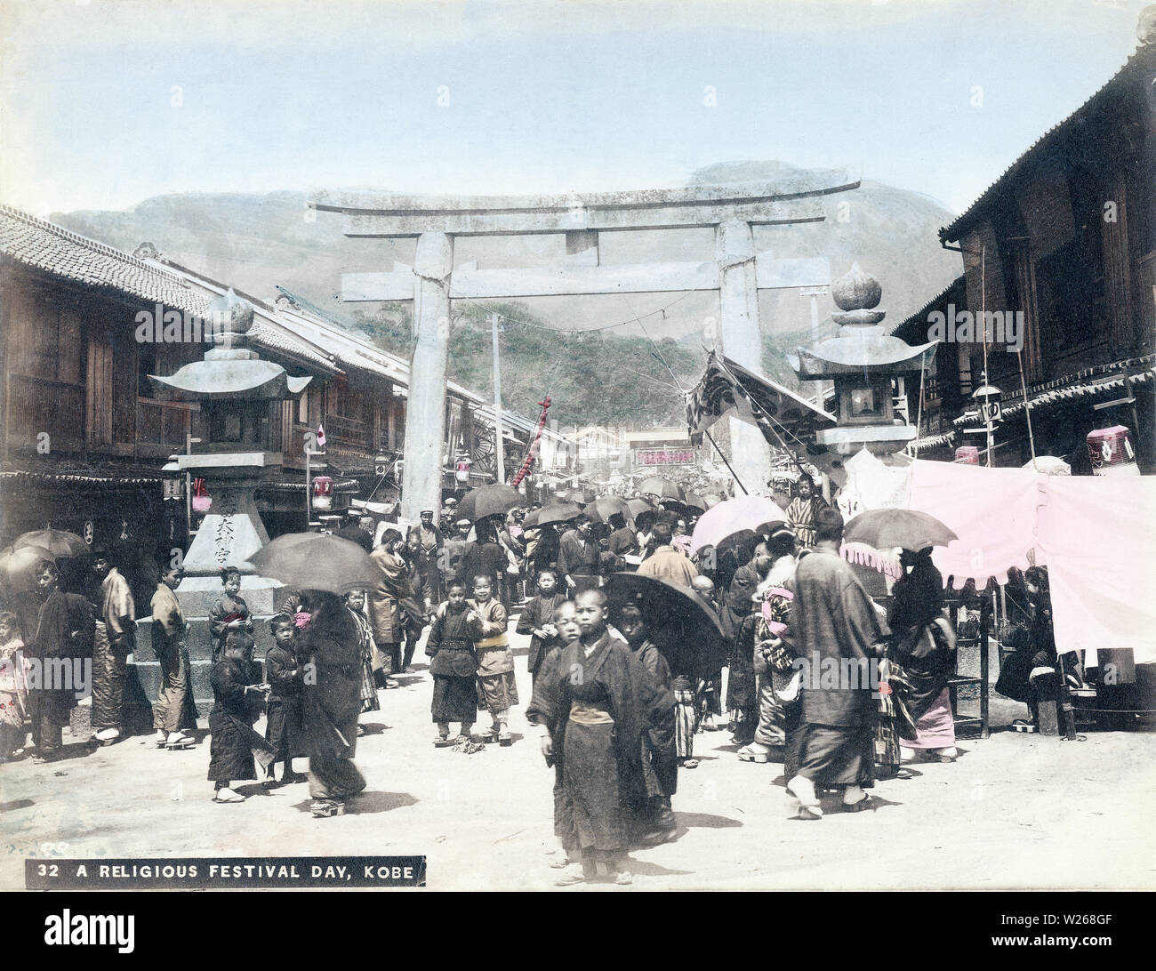 [ 1890s Japan - Ikuta Jinja Matsuri, Kobe ] —   A crowd enjoying a matsuri (religious festival) surrounds the stone lanterns and scared torii gate at the entrance way to Ikuta Jinja, a Shinto shrine in Kobe, Hyogo Prefecture. The shrine is among the oldest shrines in Japan and is mentioned in the Nihon Shoki, the second oldest book of classical Japanese history. The Battle of Ichi-no-Tani (1184) took place in and around Ikuta Shrine.  19th century vintage albumen photograph. Stock Photo