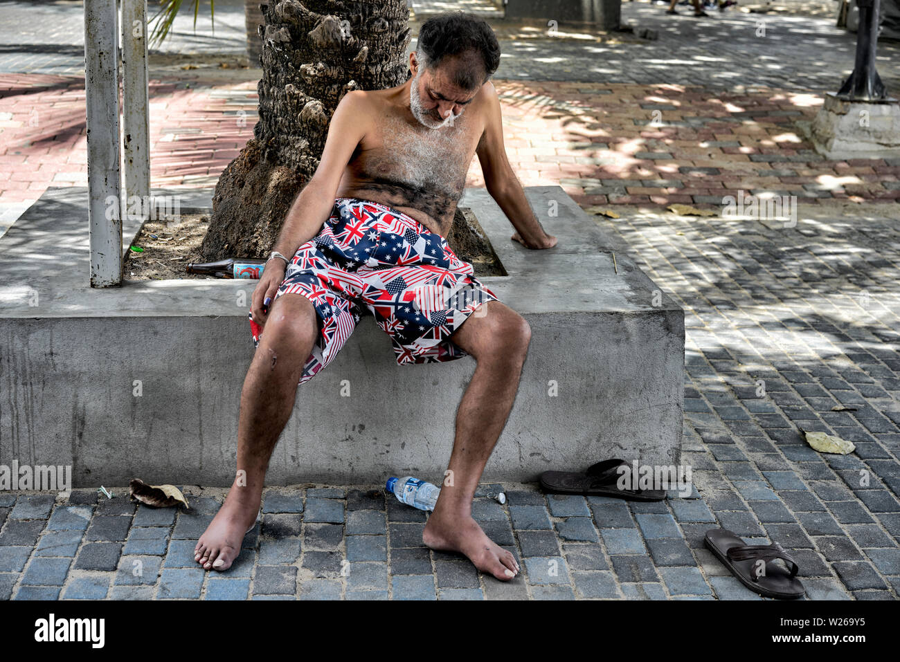 Drunken tourist asleep on the street. Pattaya Thailand S. E. Asia. Stock Photo