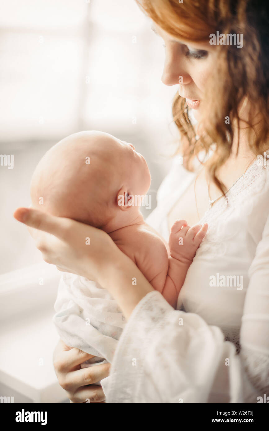 A young girl, mother in the hospital with a newborn. The concept of care and care for newborns. Stock Photo