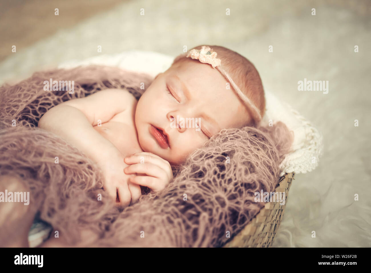 Newborn baby girl sleeping in a basket. Concept shooting newborns, innocence. Stock Photo
