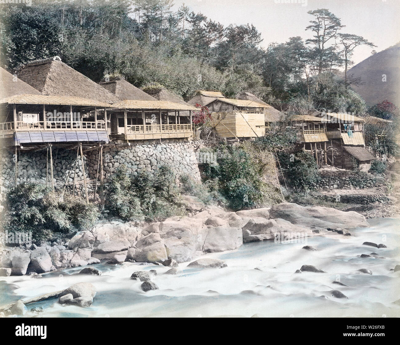 [ 1880s Japan - Japanese Teahouses along a River, Hakone ] —   Teahouses with thatched roofs along the Hayakawa River at Sanmaibashi in Hakone, Kanagawa Prefecture around 1880 (Meiji 13).  19th century vintage albumen photograph. Stock Photo