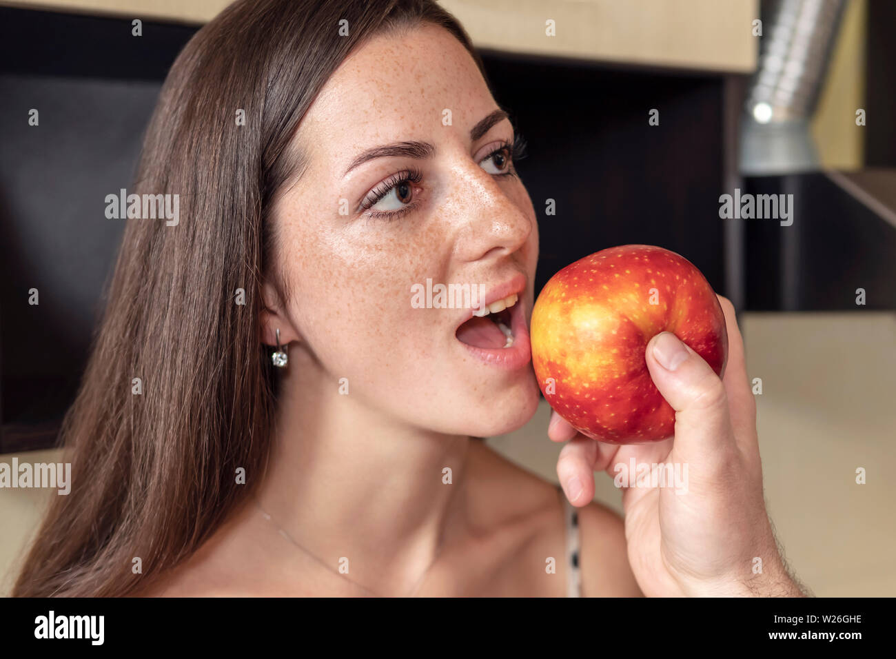 Male Hand Feeds An Apple Beautiful Freckled Woman With An Open
