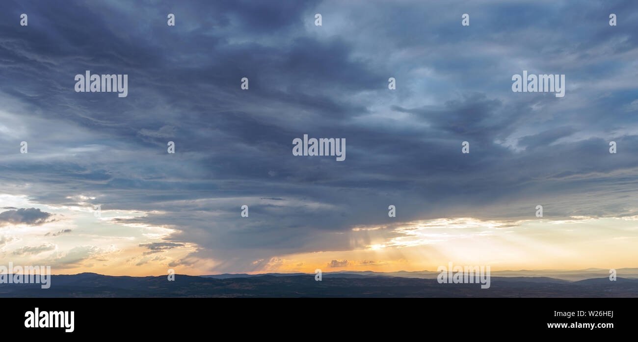 Rays of light shining throug dark clouds Stock Photo