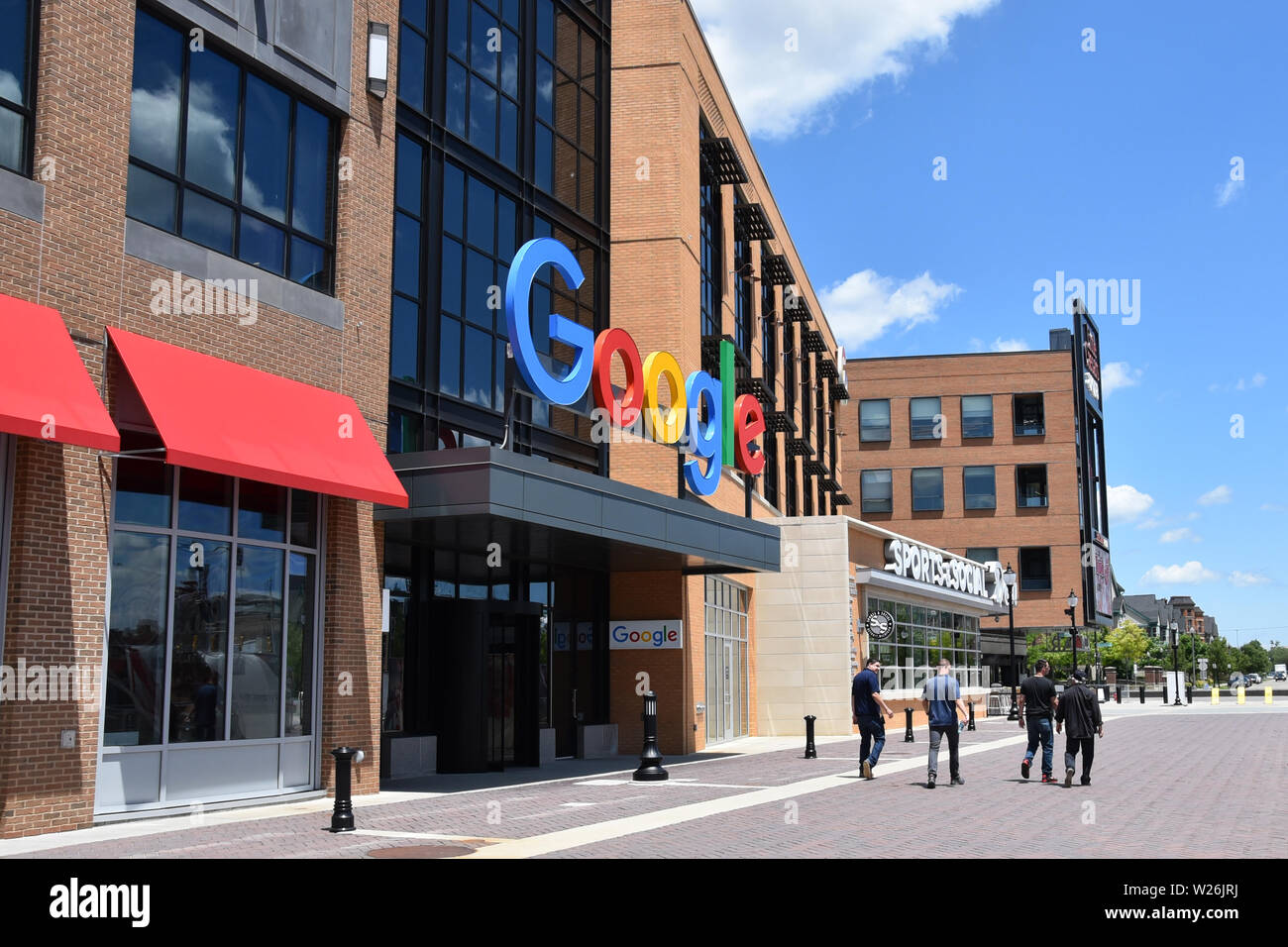 DETROIT, MI / USA - JUNE 30, 2019:  People walk past the new Google offices next to the Little Caesars arena. Stock Photo