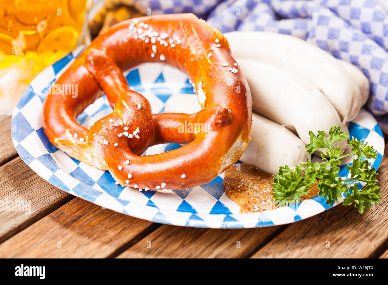 pretzel and white sausage on bavarian style dishes on wooden table Stock Photo