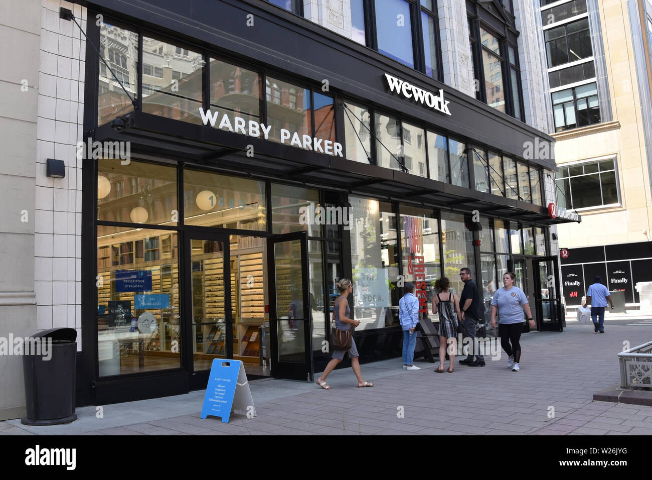 DETROIT, MI / USA - JUNE 30, 2019:  People walk past the Warby Parker store and wework coworking space in downtown Detroit. Stock Photo
