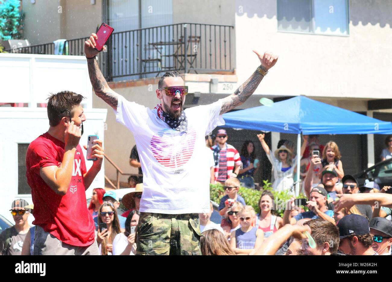 San Clemente, California, USA. 4th July, 2019. During the middle of the San Clemente Fourth of July Office Chair Downhill Derby event, the host was passing out water balloons to people in the crowd and wishing them a happy July 4th. Credit: Katrina Kochneva/ZUMA Wire/Alamy Live News Stock Photo