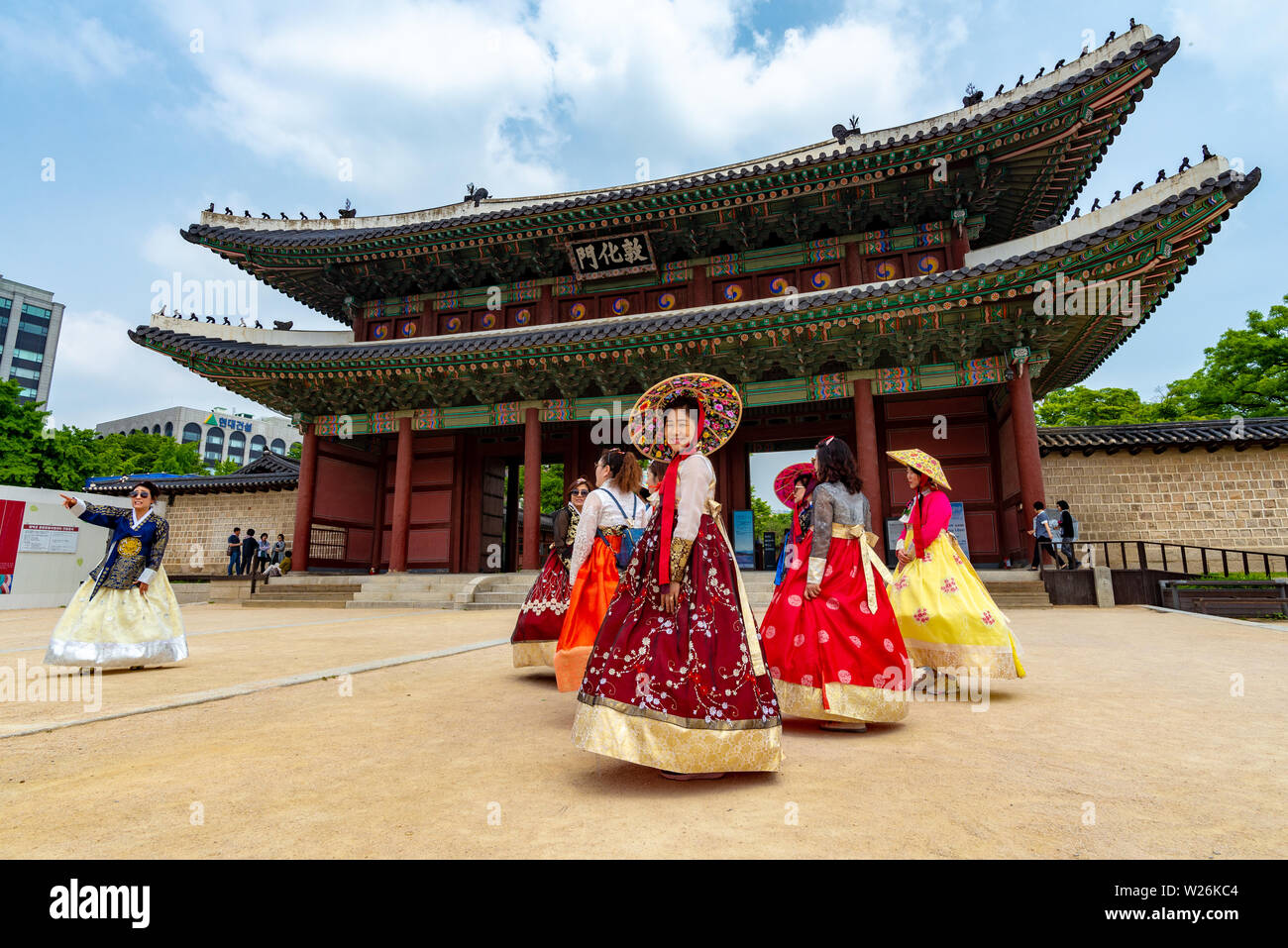 SEOUL, SOUTH KOREA - JUNE 1, 2019: A group of women in traditional korean costume are about to enter the Changdeokgung Palace through the main gate Stock Photo