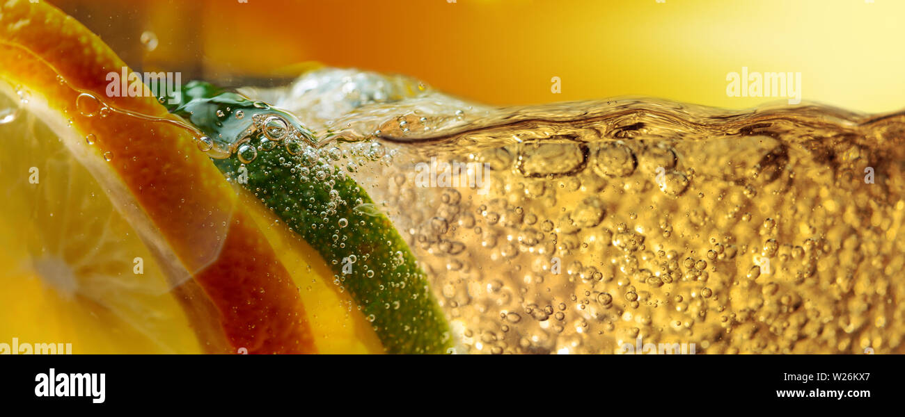 Carbonated drink or cocktail with lemon and lime, abstract splashing. Macro shot. Copy space. Stock Photo