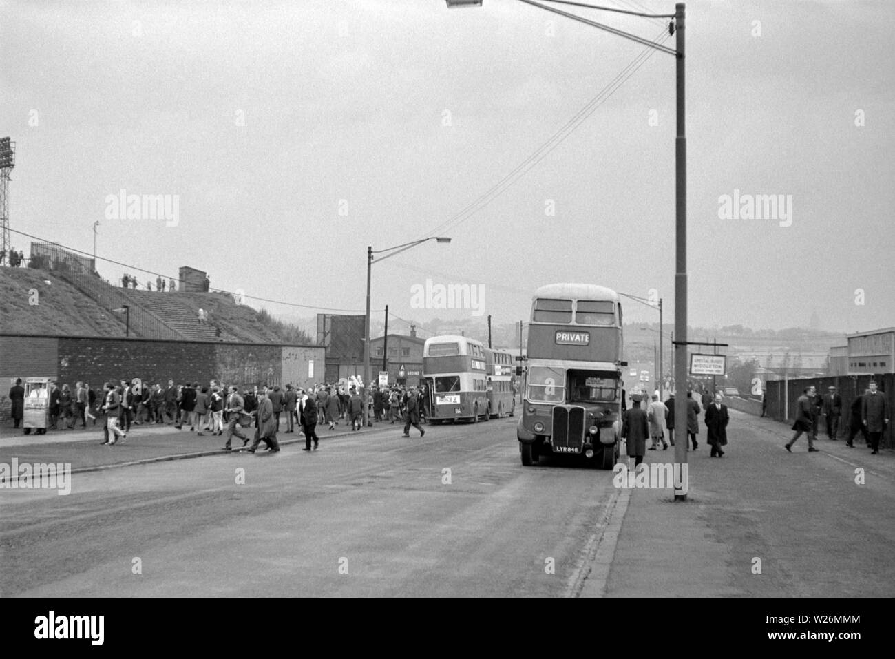 Match Day at Leeds United Football Ground. Probably taken during the 1960s, the image shows the home side fans getting of the busses to see their team in action. The main bus in the image is a Waymann Bodied AEC Regent III that would have been new in 1952 Stock Photo