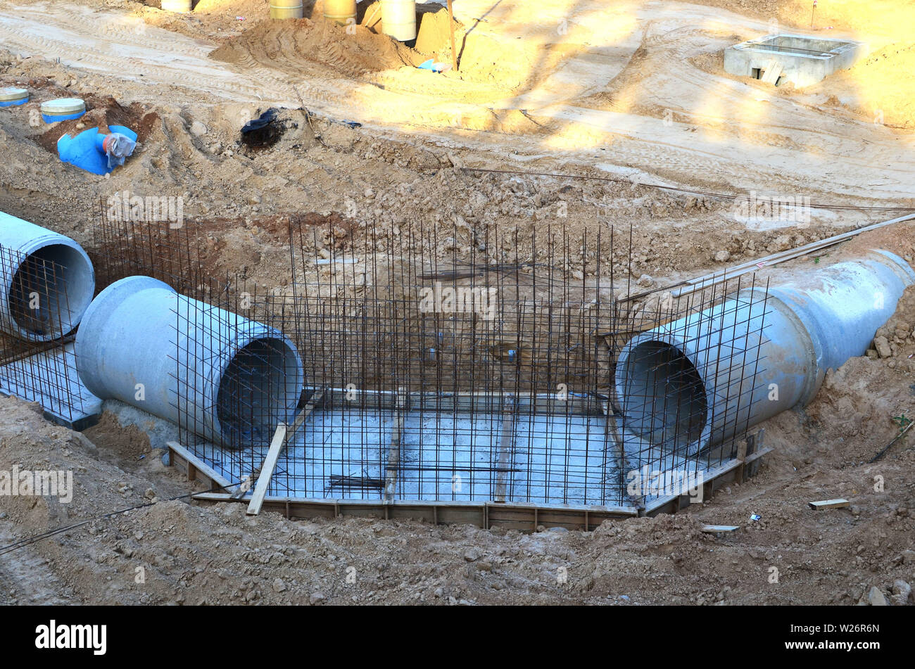 Laying or replacement of underground storm sewer pipes. Installation of water main, sanitary sewer, storm drain systems in city. Concrete drainage pip Stock Photo