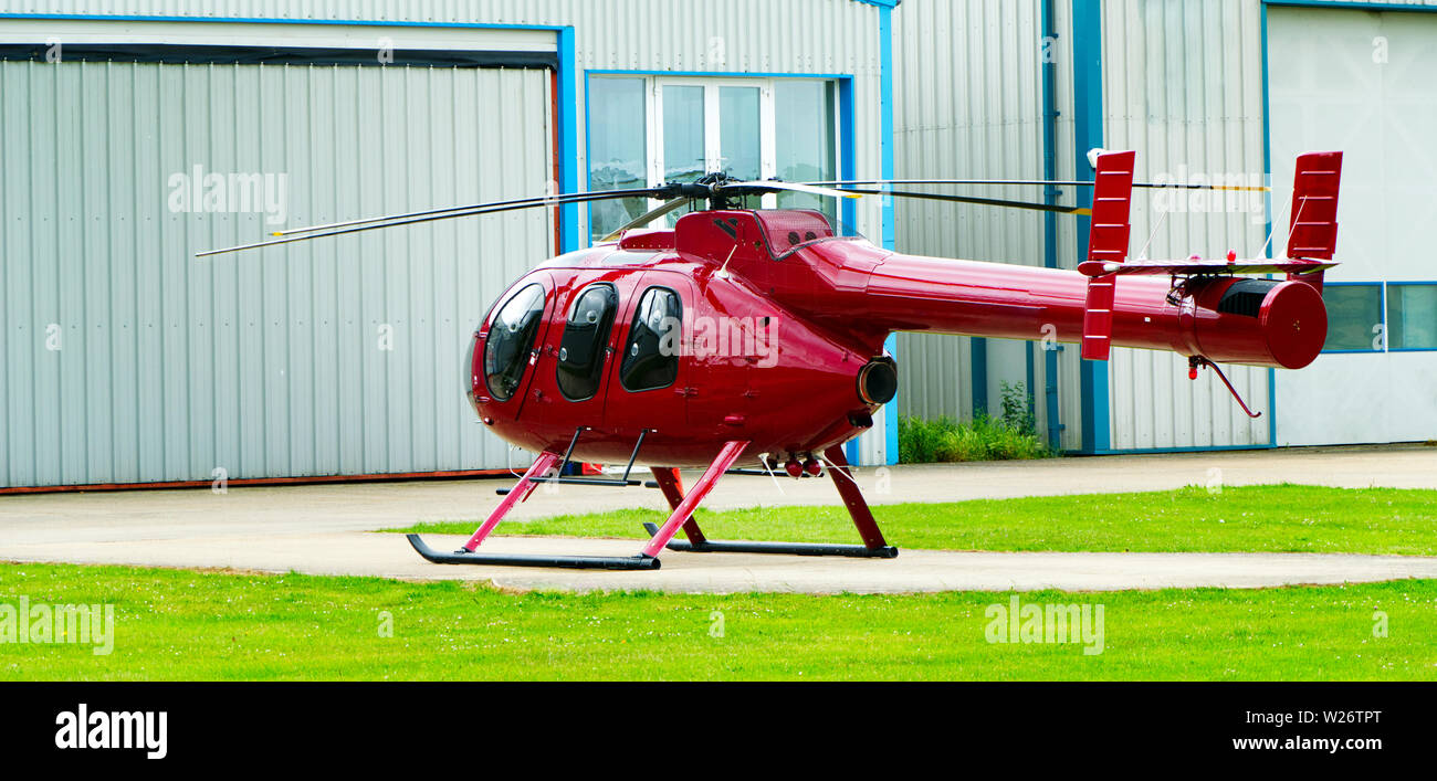 Red Helicopter landed facing away Stock Photo
