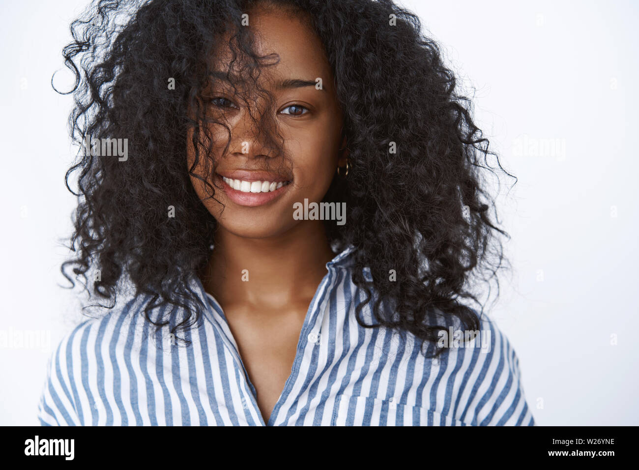 Close-up positive carefree happy good-looking smiling african-american fashioable woman playing curly afro haircut grinning happily expressing positiv Stock Photo