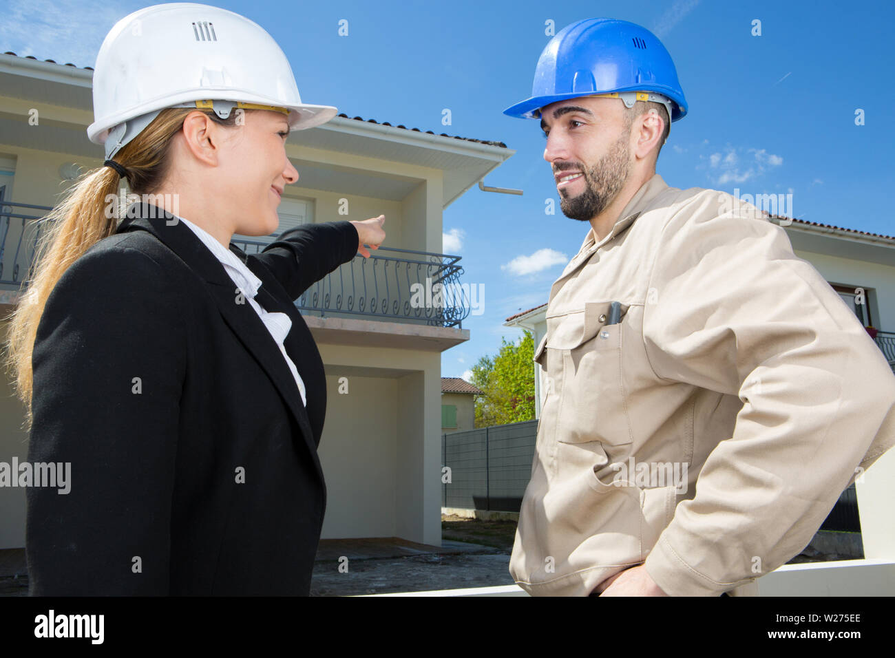 Point Up Construction architect pointing to construction building plan to builder Stock Photo ...