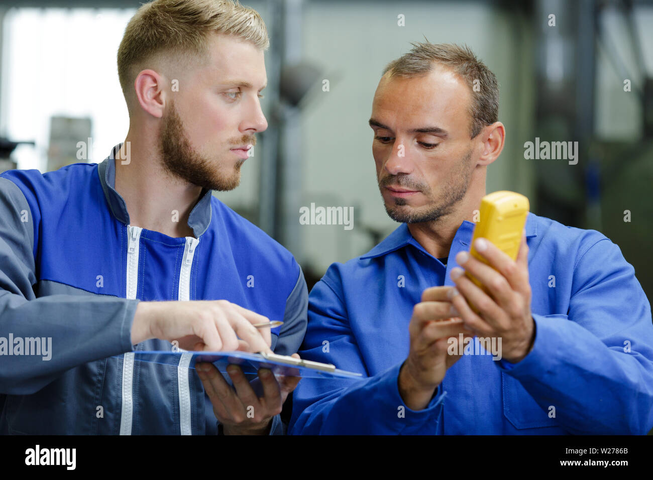 technicians measure contract resistance in control panel Stock Photo