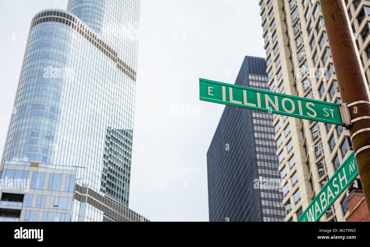 Chicago city downtown, Cityscape, spring day. Illinois street and Wabash avenue crossing green sign, City high rise buildings background, low angle vi Stock Photo