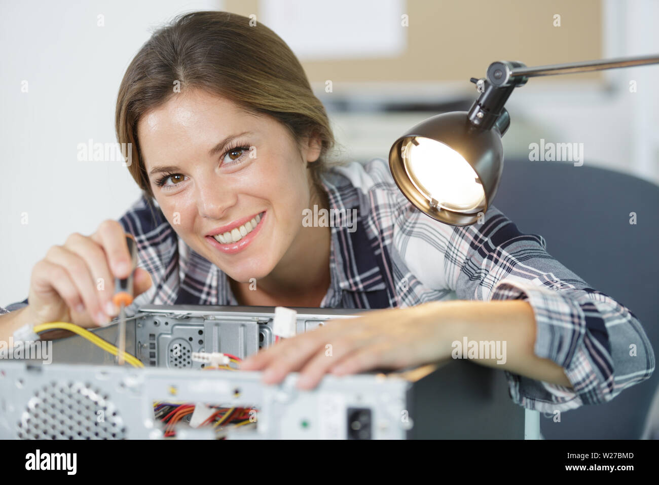 happy female technician plug in cpu microprocessor to motherboard socket Stock Photo