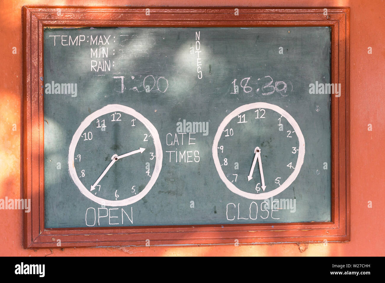 display or sign board on the wall at Nossob rest camp in Kgalagadi Transfrontier Park, South Africa with clocks displaying gate open and close time Stock Photo