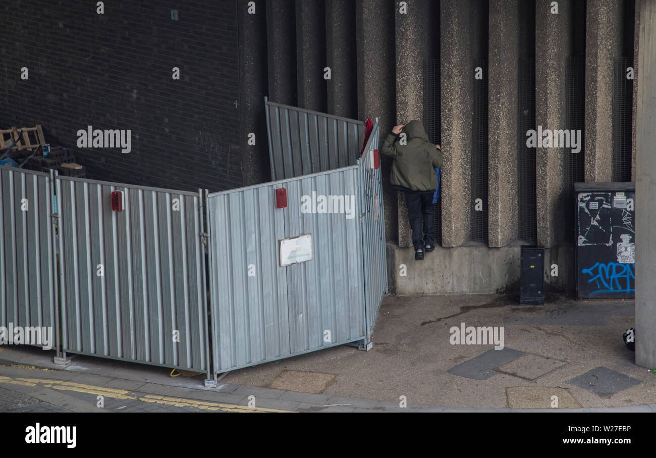 A homeless person is climbing into his shelter under The London Bridge, London 2019 Stock Photo