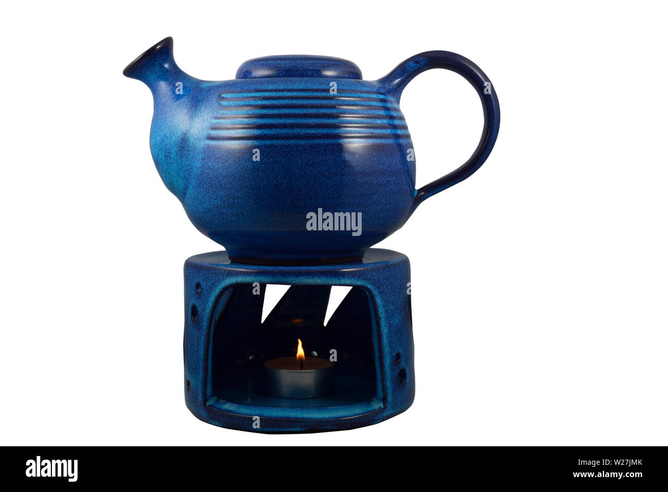 blue ceramic teapot with a candle heated on a white background Stock Photo Alamy