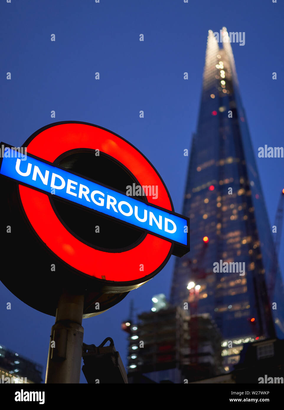 London, UK - February, 2019. A typical Underground sign with the Shard on the background at dusk. Stock Photo