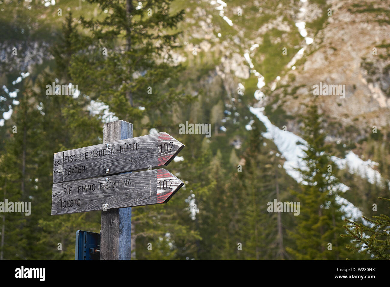Wooden hiking trail signs on a pole along a trail on the Dolomites Alps in the region of Trentino-Alto Adige (Italy). Landscape format. Stock Photo