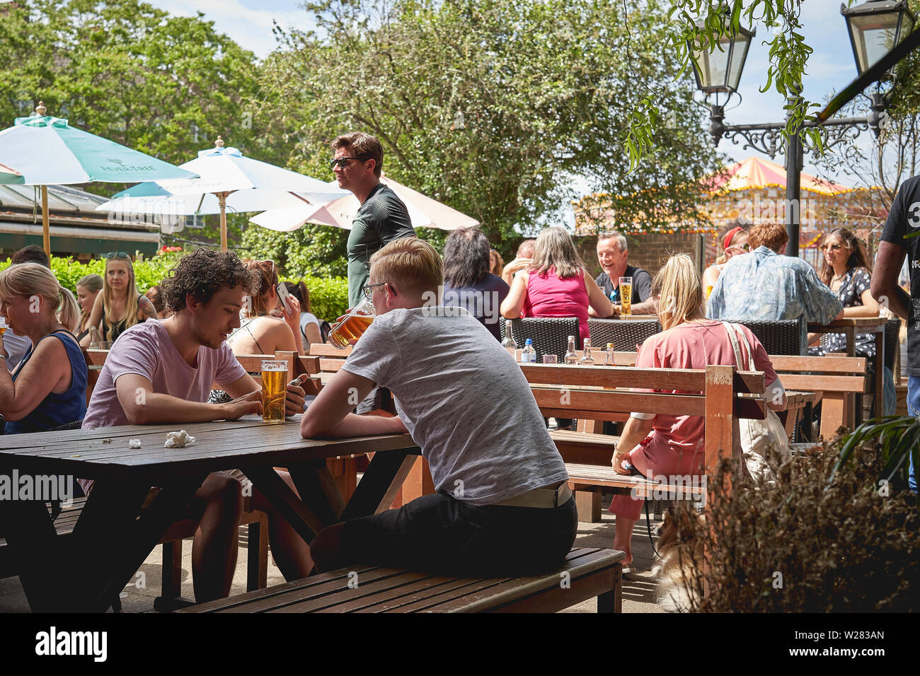 London, UK June, 2019. Young people in a beer garden pub in Greenwich