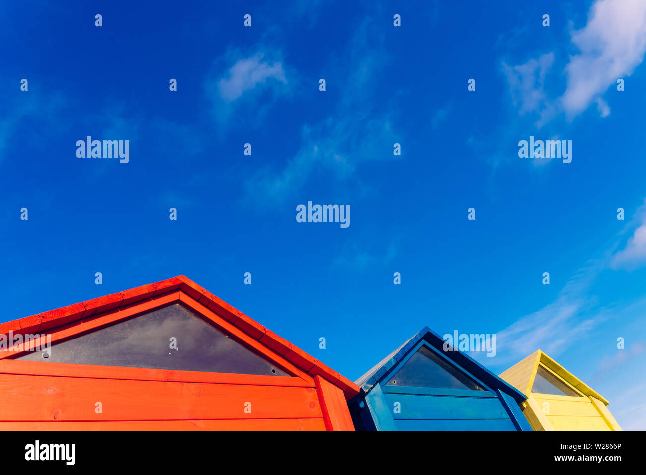 Strange design of colorful wooden triangular boards with blue sky background with clouds. Stock Photo