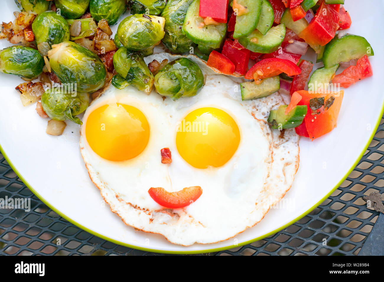 Healthy breakfast, two eggs, a sald,  and brussel sprouts Stock Photo