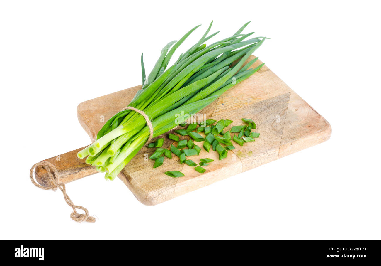 Use of fresh green onions in cooking, kitchen wooden board.  Stock Photo