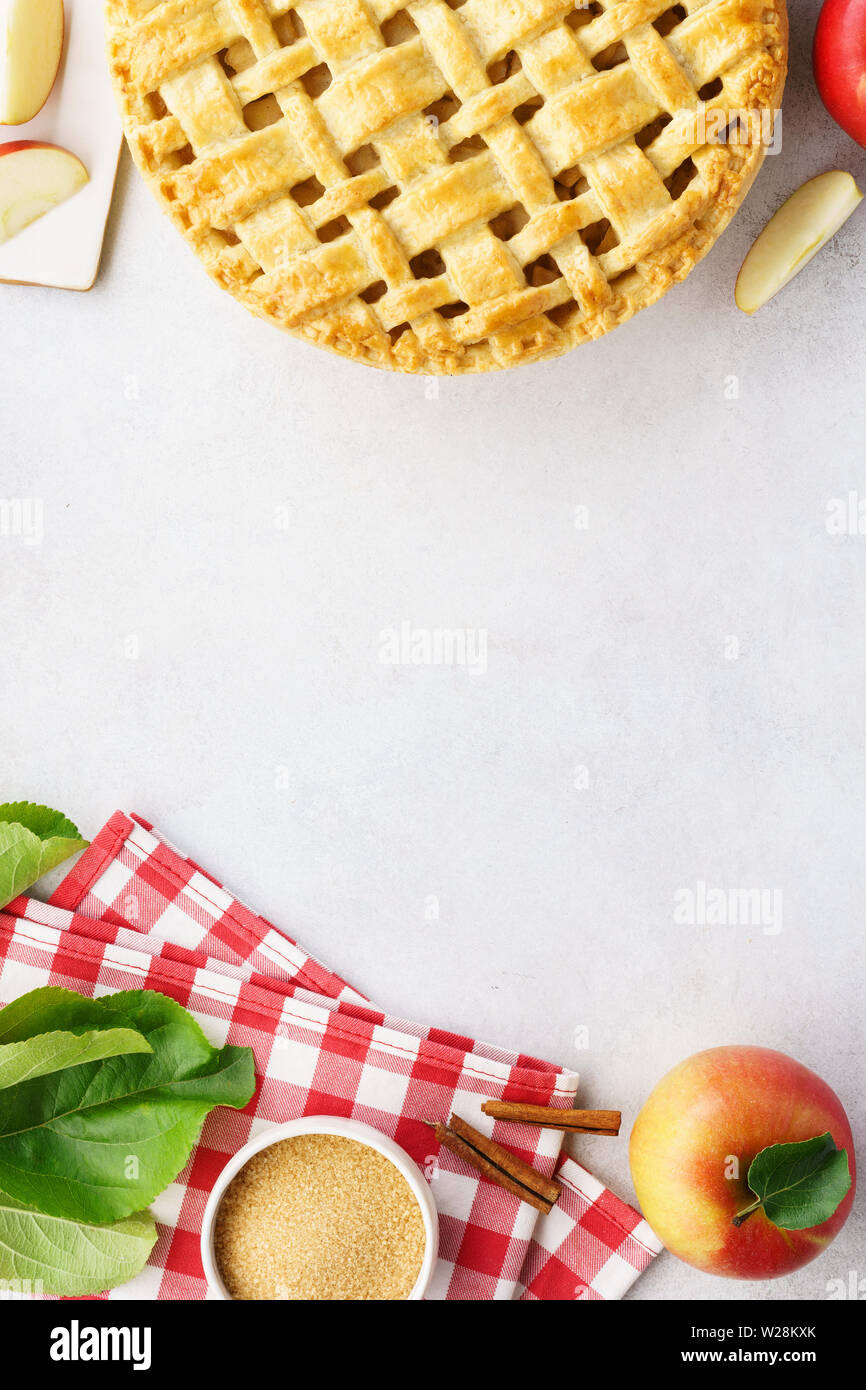 Homemade apple pie with lattice top and ingredients on gray table. Traditional American seasonal pastry background. Copy space. Stock Photo