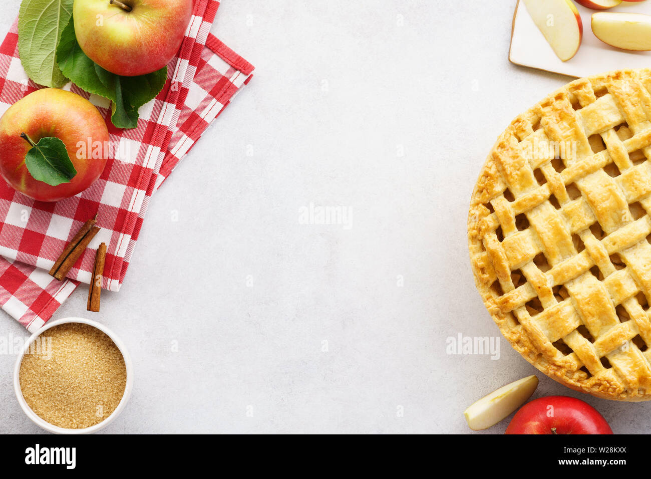 Homemade apple pie with lattice top and ingredients on gray table. Traditional American seasonal pastry background. Copy space. Stock Photo