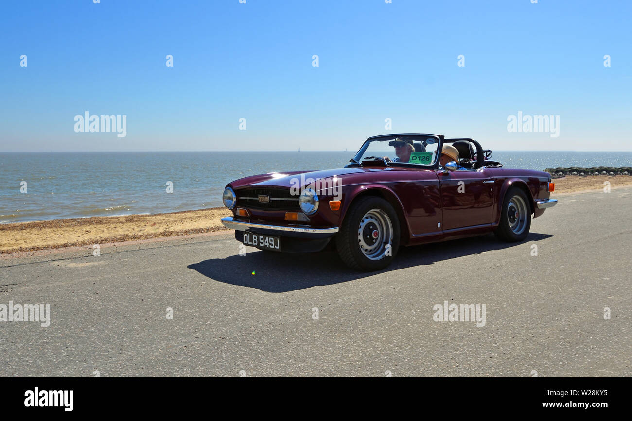 Classic Purple Triumph TR6 Sports Car being driven along Seafront  Promenade. Stock Photo