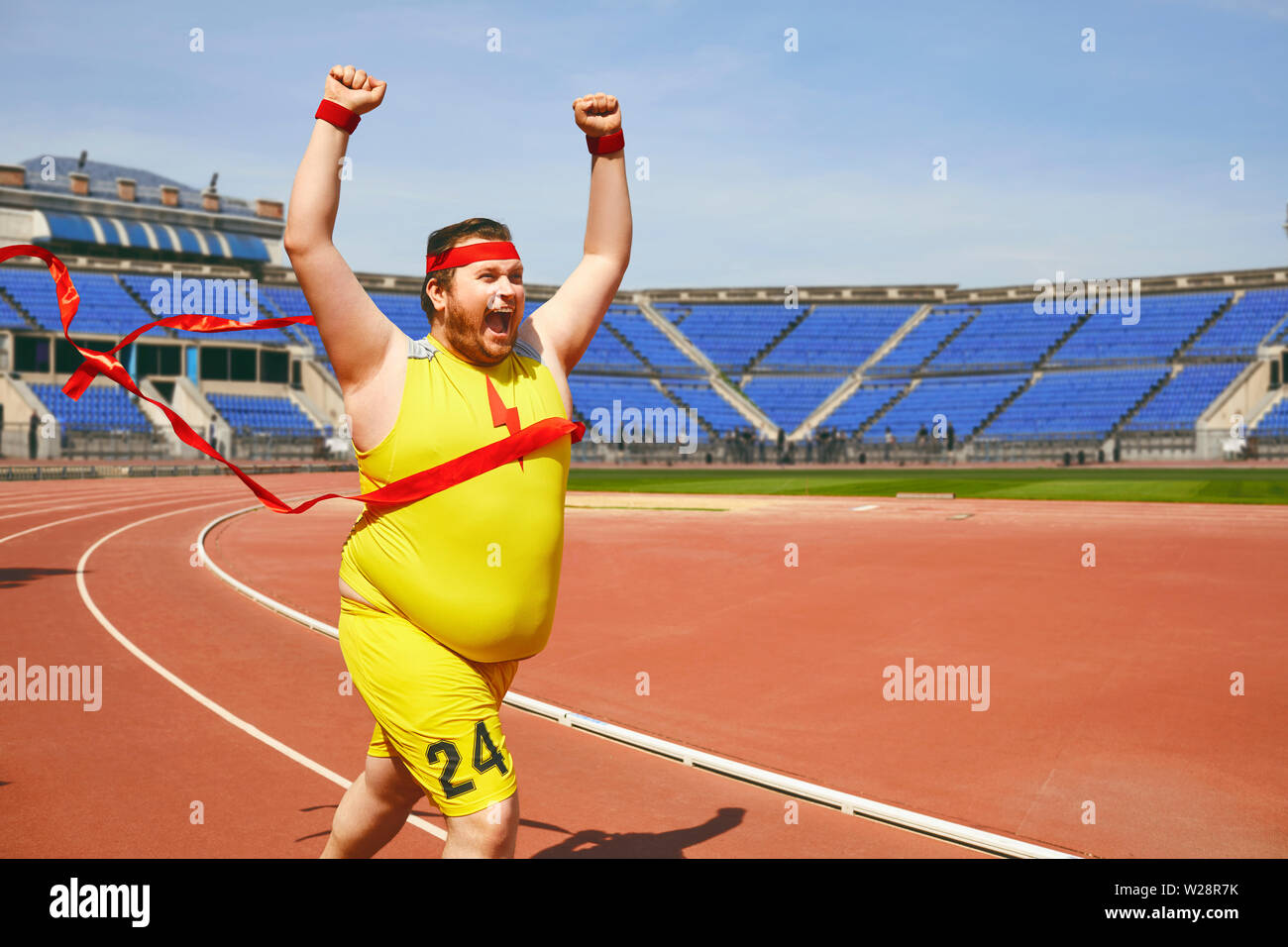 A fat man in sportswear runs to the finish line with a red ribbon on