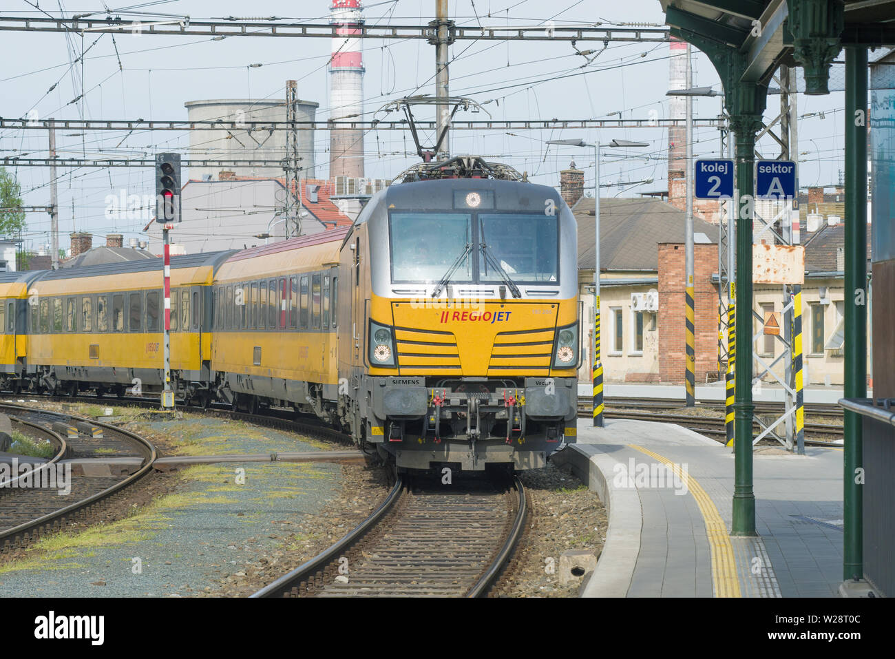 BRNO, CZECH REPUBLIC - APRIL 24, 2018: The yellow passenger train of the RegioJet company arrives to the railway station of the city of Brno Stock Photo