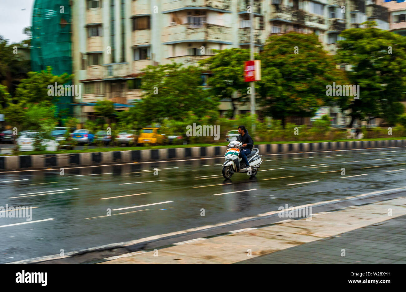 Mumbai, India - June 30, 2019 : Unidentified kid driving motorbike with Indian flag on streets of Marine drive Stock Photo