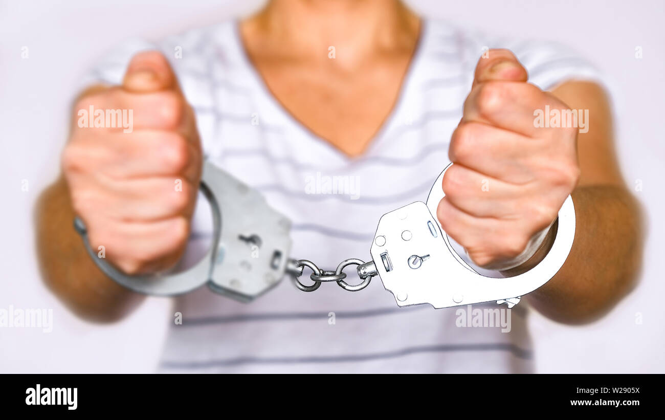 Detained woman at the police station. Handcuffs on the wrists of the detainee Stock Photo