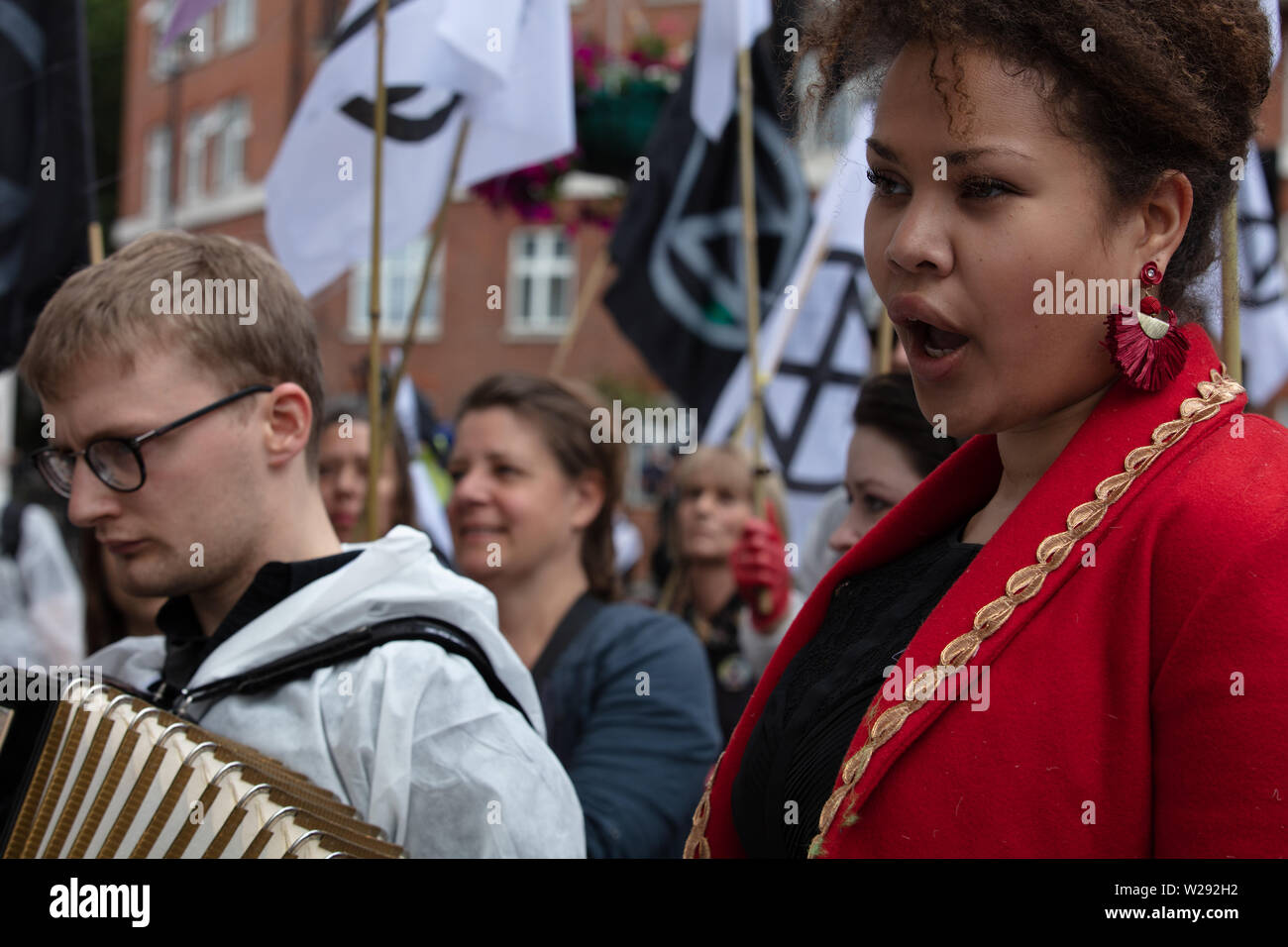 London, UK. 2nd July 2019. Extinction Rebellion Arts and Culture Group creating a silent procession to and theatre in front of several fossil fuel companies. The protest play is based on Bizet's opera Carmen, with real life actors and an opera singer. Pictured: opera singer Simone Ibbett-Brown sings a song from the opera Carmen during the protest, the text adapted for the occasion. Credit: Joe Kuis / Alamy News Stock Photo