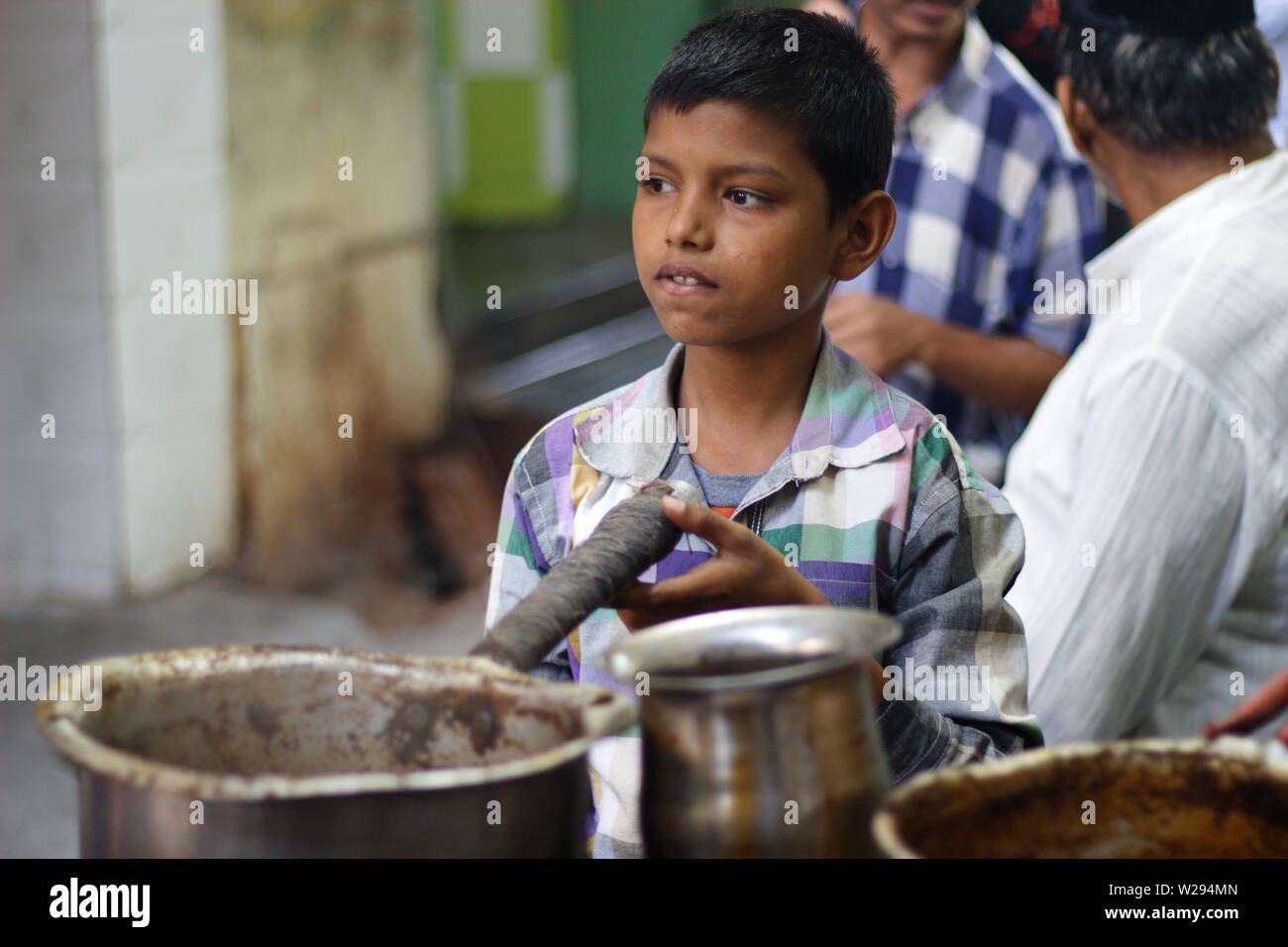 A young boy making tea at a small tea stall in Ajmer, Rajasthan, India Stock Photo